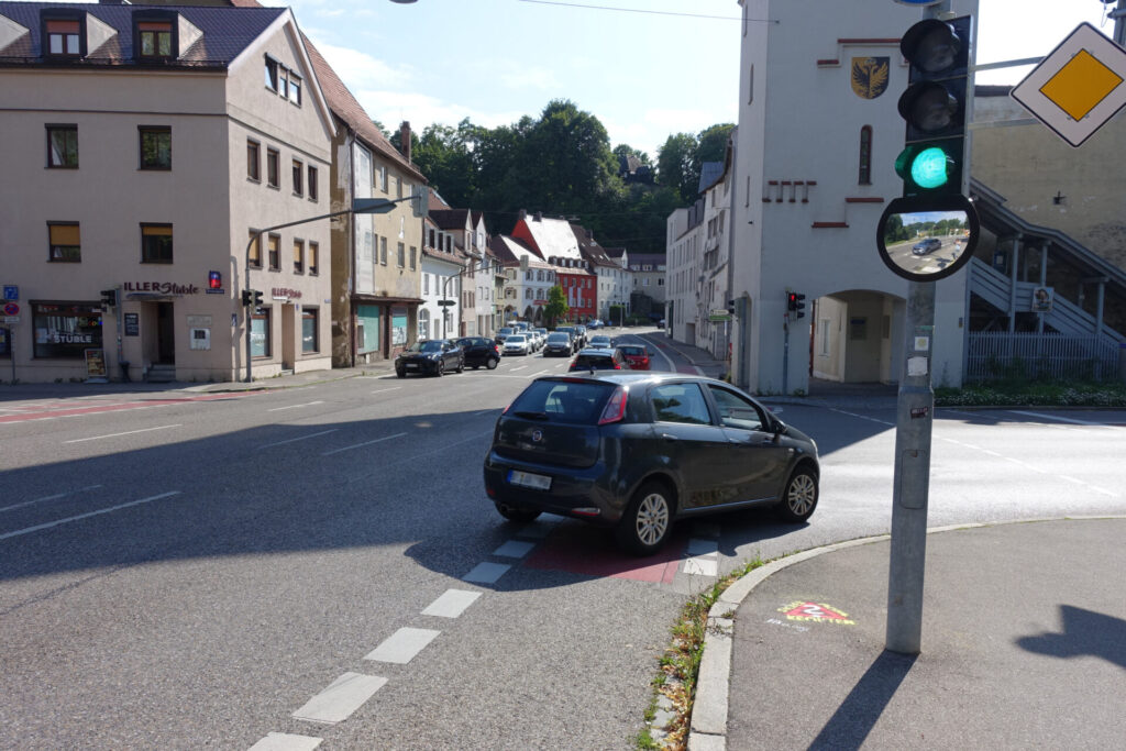 Rechts abbiegendes Auto, das über Radweg fährt