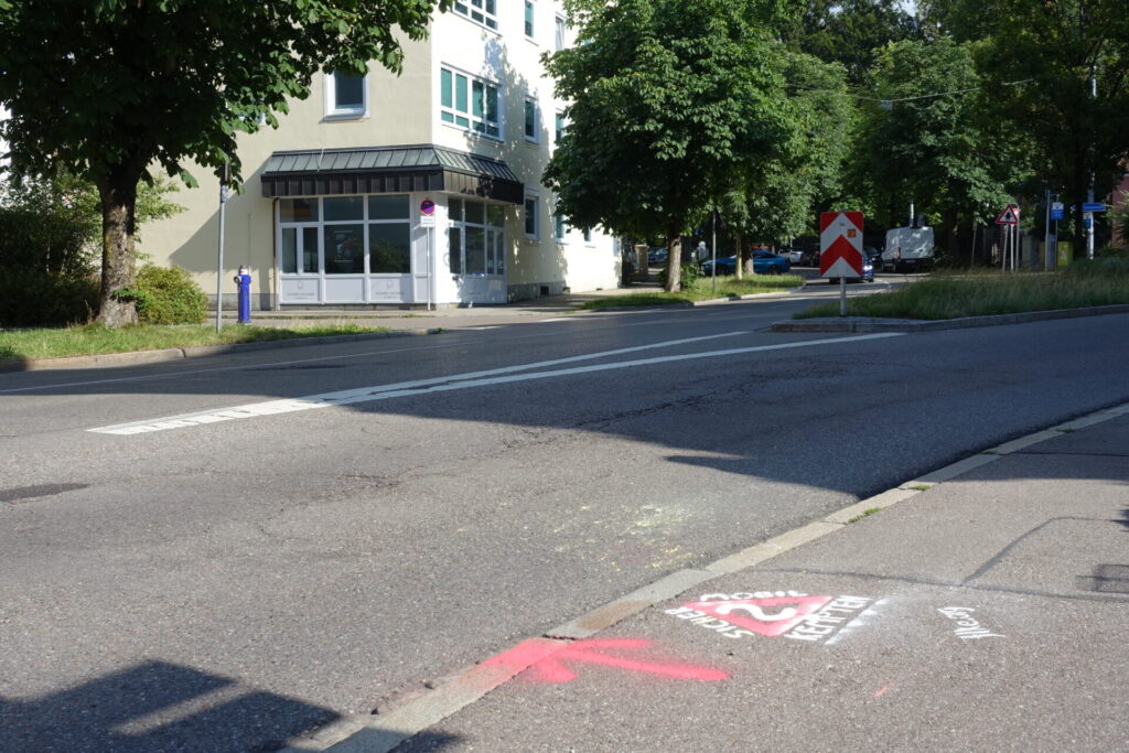 Graffito "SIcher mobil in Kempten?" auf Gehweg, mit Pfeil in Richtung Mozartstraße