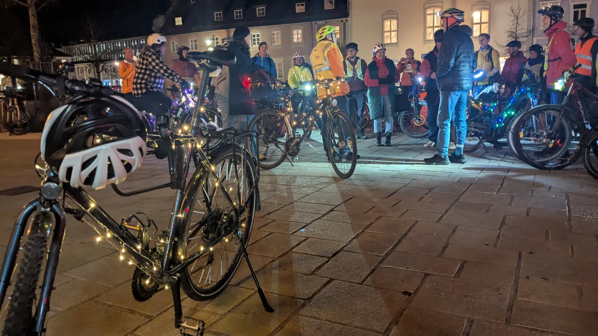 Fahrradfahrer und mit Lichterketten dekorierte Fahrräder