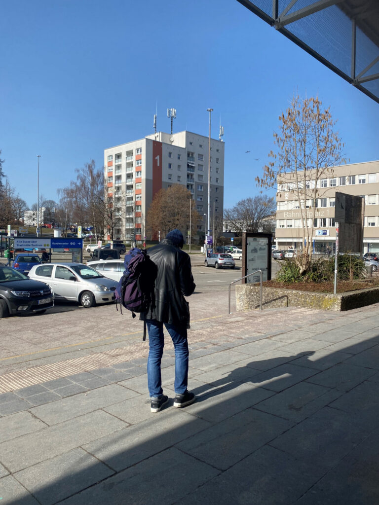 Person mit Rucksack am Hauptbahnhof Kempten