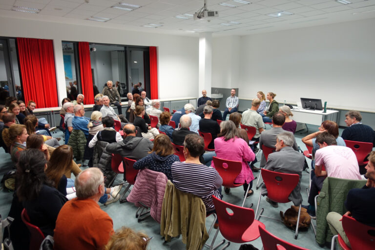 Raum mit Publikum von hinten bei Podiumsdiskussion